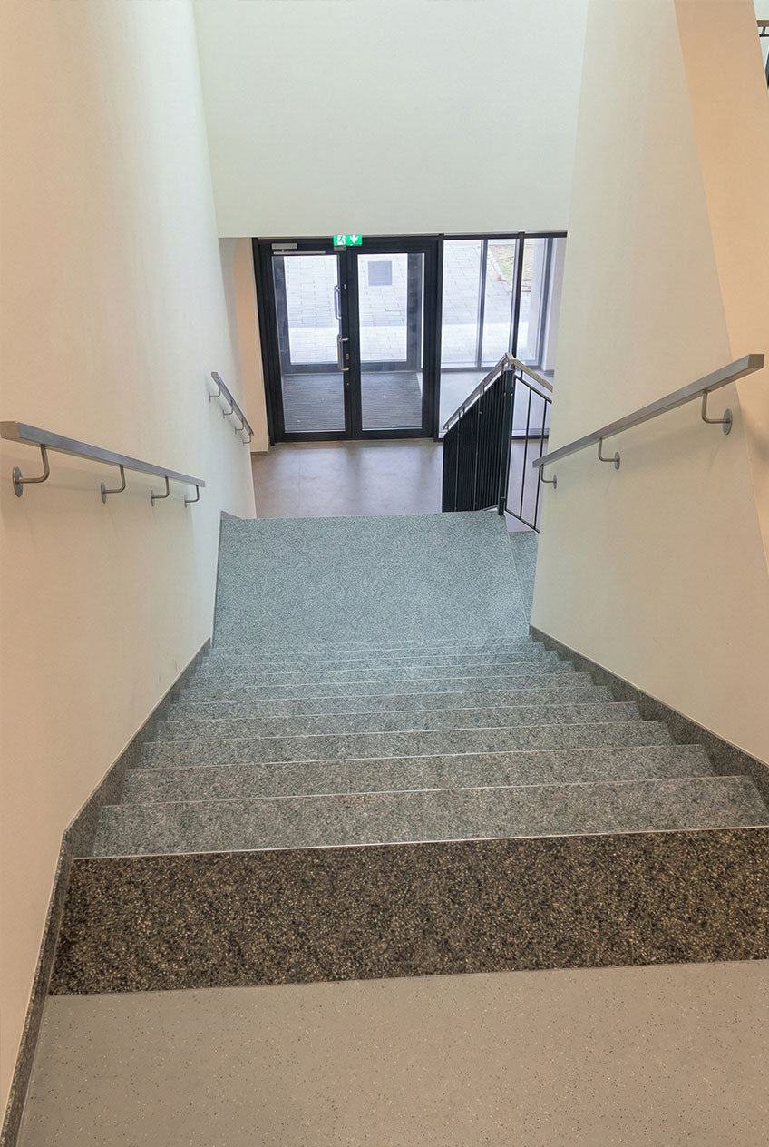 Steinteppich-Komplettset für den Innenbereich verlegt als Stiege in einem Bürogebäude